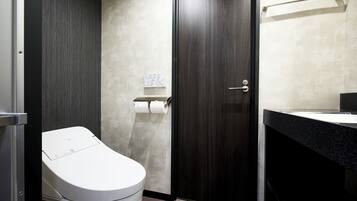 A modern bathroom with a toilet, a towel rack, and a sink.