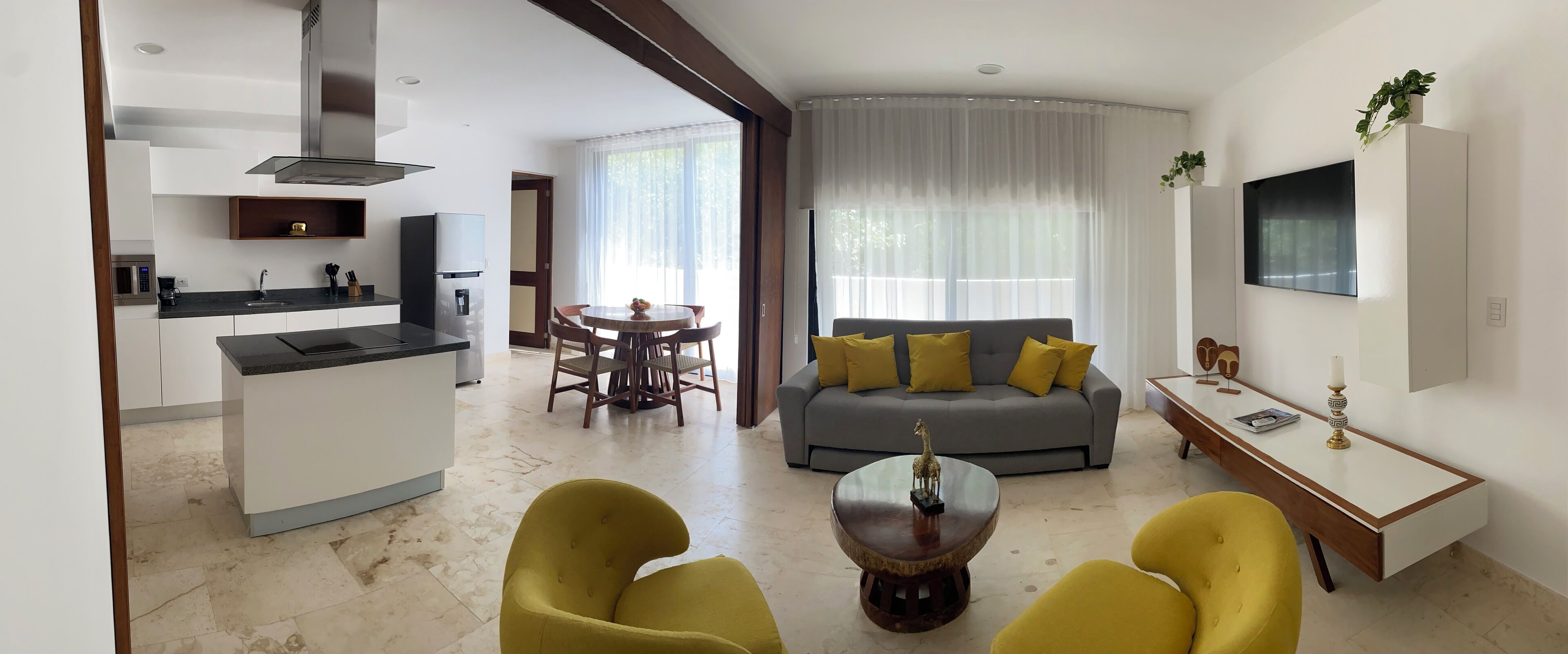 A modern living room with a grey sofa, yellow cushions, and a coffee table.