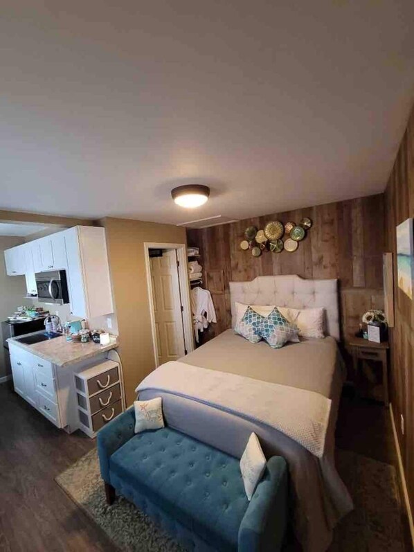 A bedroom with a bed, bedside table, and a small desk area with a chair. - Private country studio, near SMF and UC Davis Campus (Woodland)