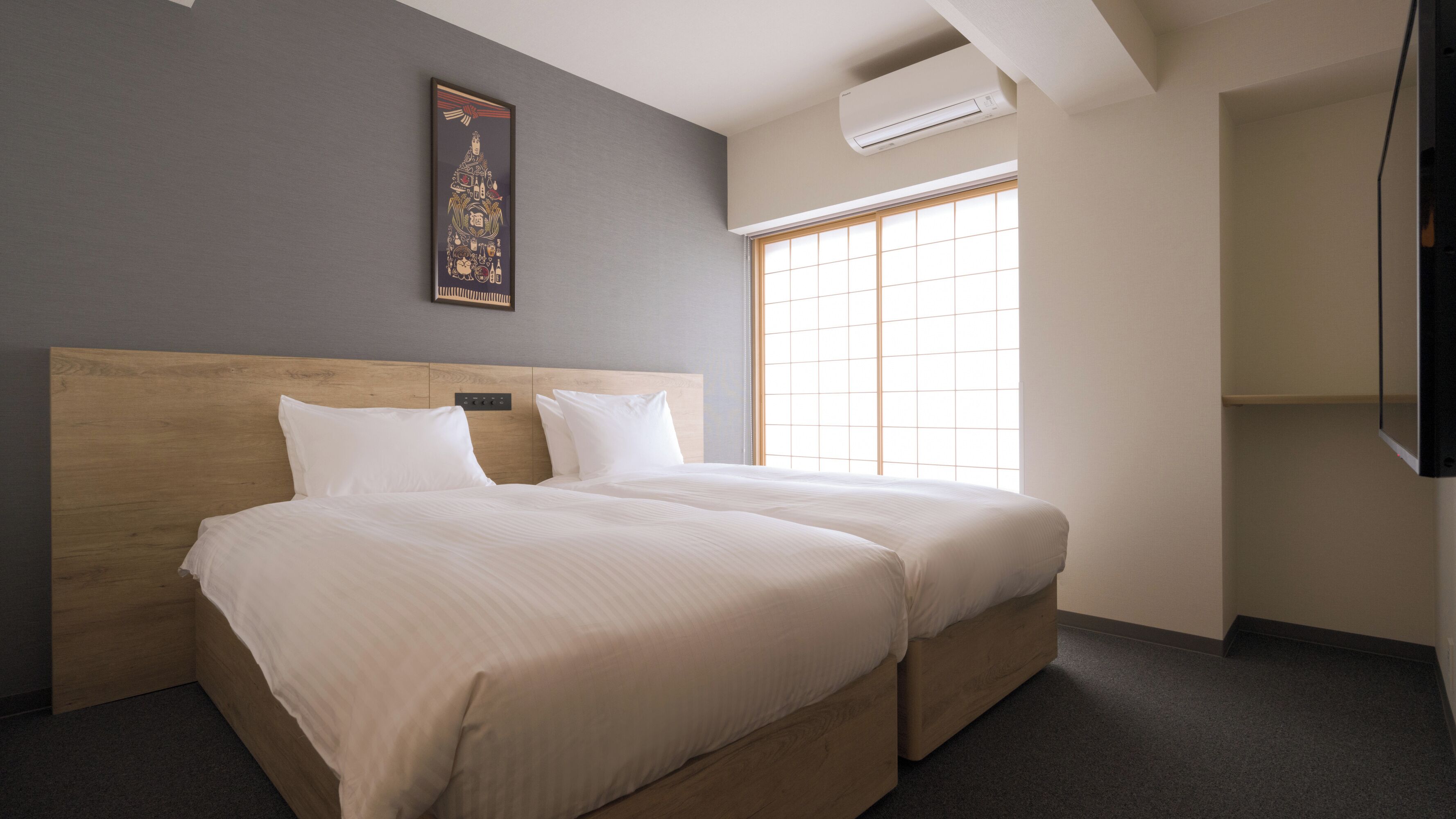 A double bed with a wooden headboard, a large window with blinds, and a wall-mounted air conditioner.