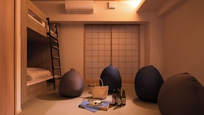 A cozy room with a bunk bed, bean bags, a woven basket, and bottles of beer on the floor. - MIMARU Osaka Shinsaibashi East (Osaka)