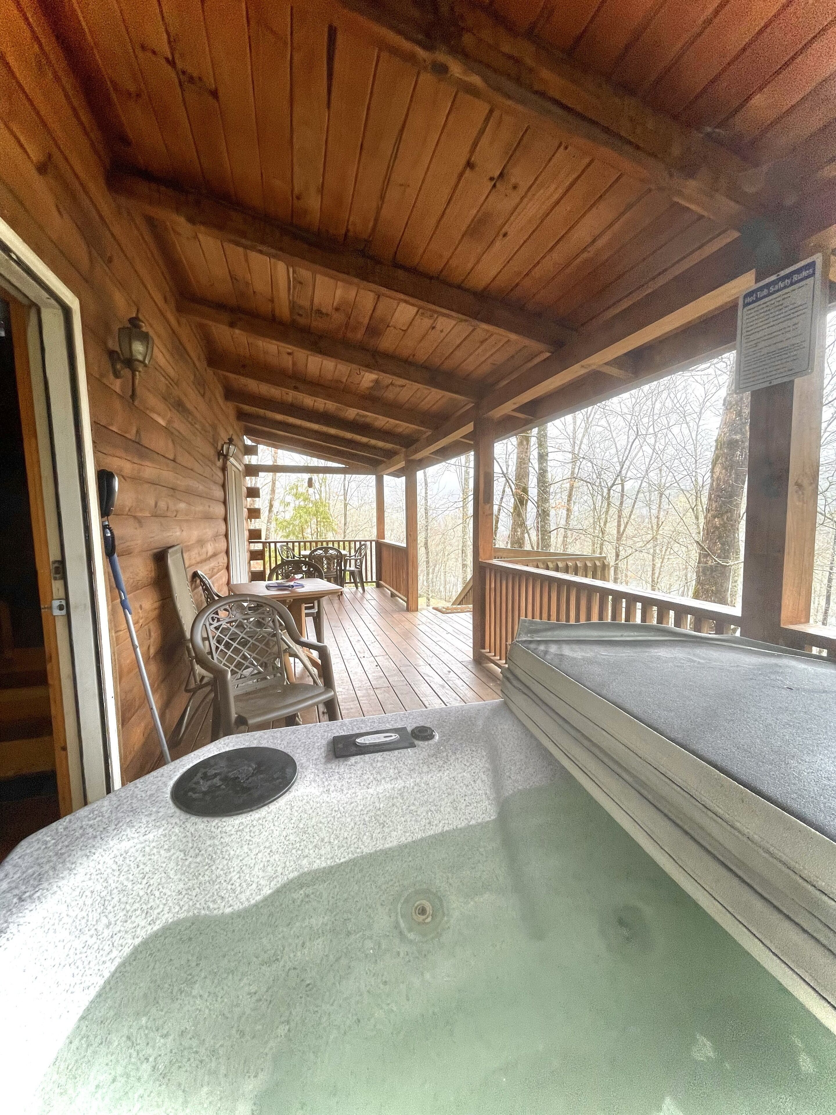 A hot tub on a wooden deck with a view of trees.