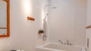 A modern bathroom with a large bathtub, a separate shower area, a wooden vanity, and a toilet. - Athena Suites R101 (Hanoi)
