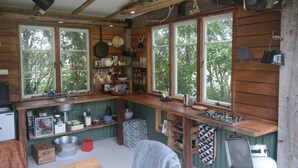 Une cuisine rustique avec des murs en bois, un évier encastré et une cuisinière à gaz.