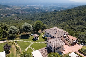 Un'ampia tenuta con diversi edifici, un prato curato e vista sulla campagna circostante.
