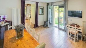 Una sala moderna con una mesa de comedor de madera, un televisor y una chimenea.