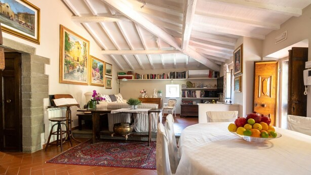 Una habitación acogedora con una cama, una mesa de comedor con fruteros, una estantería y una chimenea.
