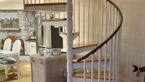 A spiral staircase with white railings and wooden steps, leading to an upper floor. - Bayfront Bungalow (Cape May Court House)