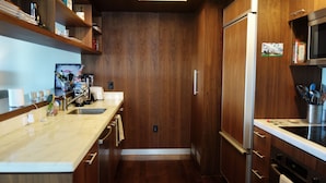 Een moderne keuken met houten kastjes, een roestvrijstalen koelkast en een magnetron.