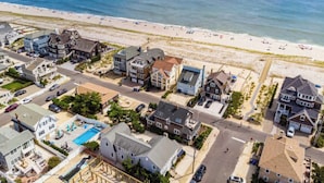 A coastal residential area with houses, a swimming pool, and a beach.