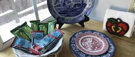 Una capsa de blat de moro torrat Gourmet Orville Redenbacher, un plat blau i blanc, i un objecte decoratiu amb forma de poma.