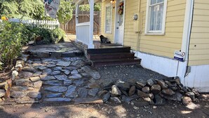 Una casa con un camino de piedra que lleva a un porche de madera.