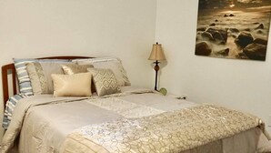Un dormitorio con cama, lámpara y un cuadro en la pared.