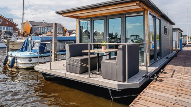 A floating house with a deck, seating area, and large windows. - De Meerparel by Interhome (Uitgeest)
