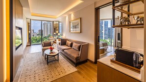 A modern living room with a sofa, coffee table, and a view of tall buildings. - The Leela Bhartiya City Bengaluru (Bengaluru)