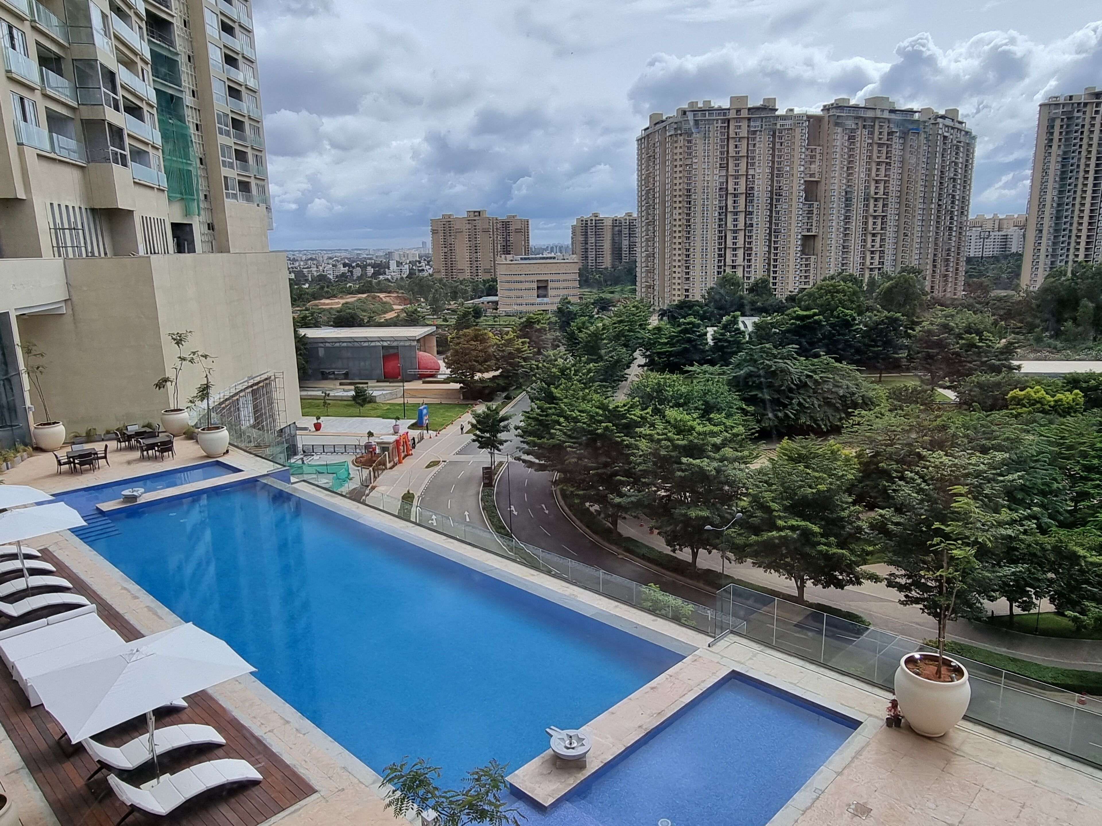 Une piscine sur le toit, dotée de chaises longues et offrant une vue sur les immeubles environnants.