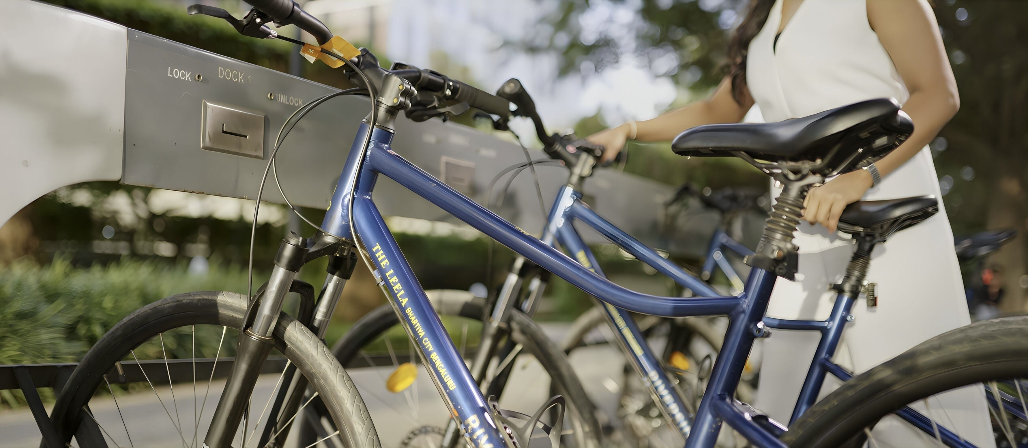 Uma bicicleta azul com sistema de trava e uma pessoa ao lado.