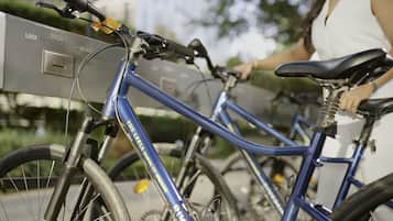 A blue bicycle with a lock mechanism and a person standing beside it.
