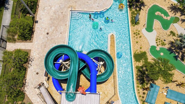 Vista aérea de un área de piscina con tobogán de agua y una piscina de olas pequeña.