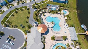 Vista aérea de un resort con varias piscinas, una piscina central grande y una zona de playa.
