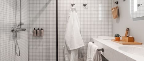 Un baño moderno con ducha, lavabo y espejo.
