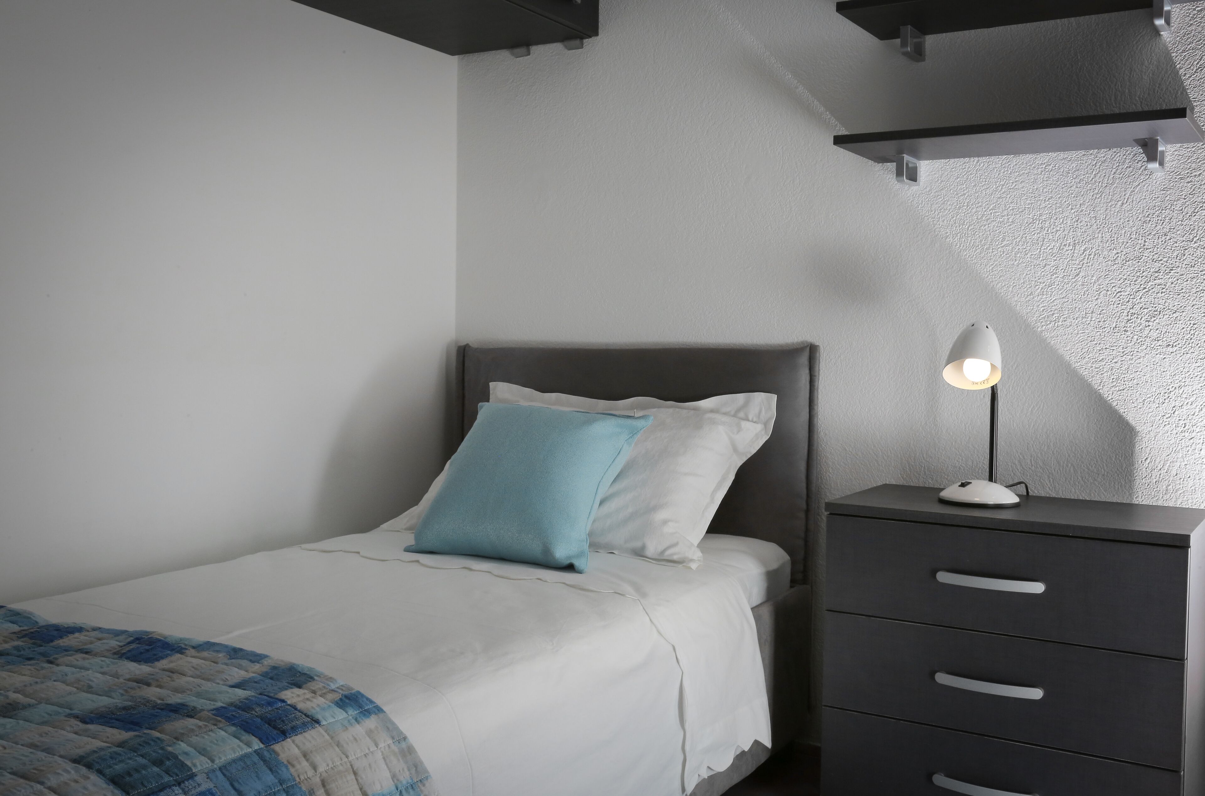 Une chambre à coucher avec un lit, une lampe de chevet et une table de chevet.
