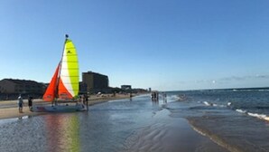 A beach with a sailboat and people in the water. - Studio on the beach! balcony ocean view, sleeps 4. pool, hot tub, BBQ. (South Padre Island)