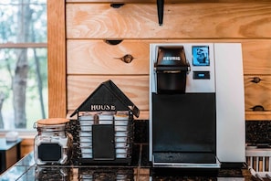 Une machine à café et un bocal de grains de café sur un plan de travail de cuisine.