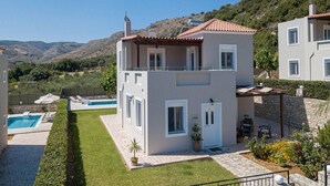 Un immeuble de deux étages doté d’une piscine, d’un balcon et offrant une vue sur les collines.