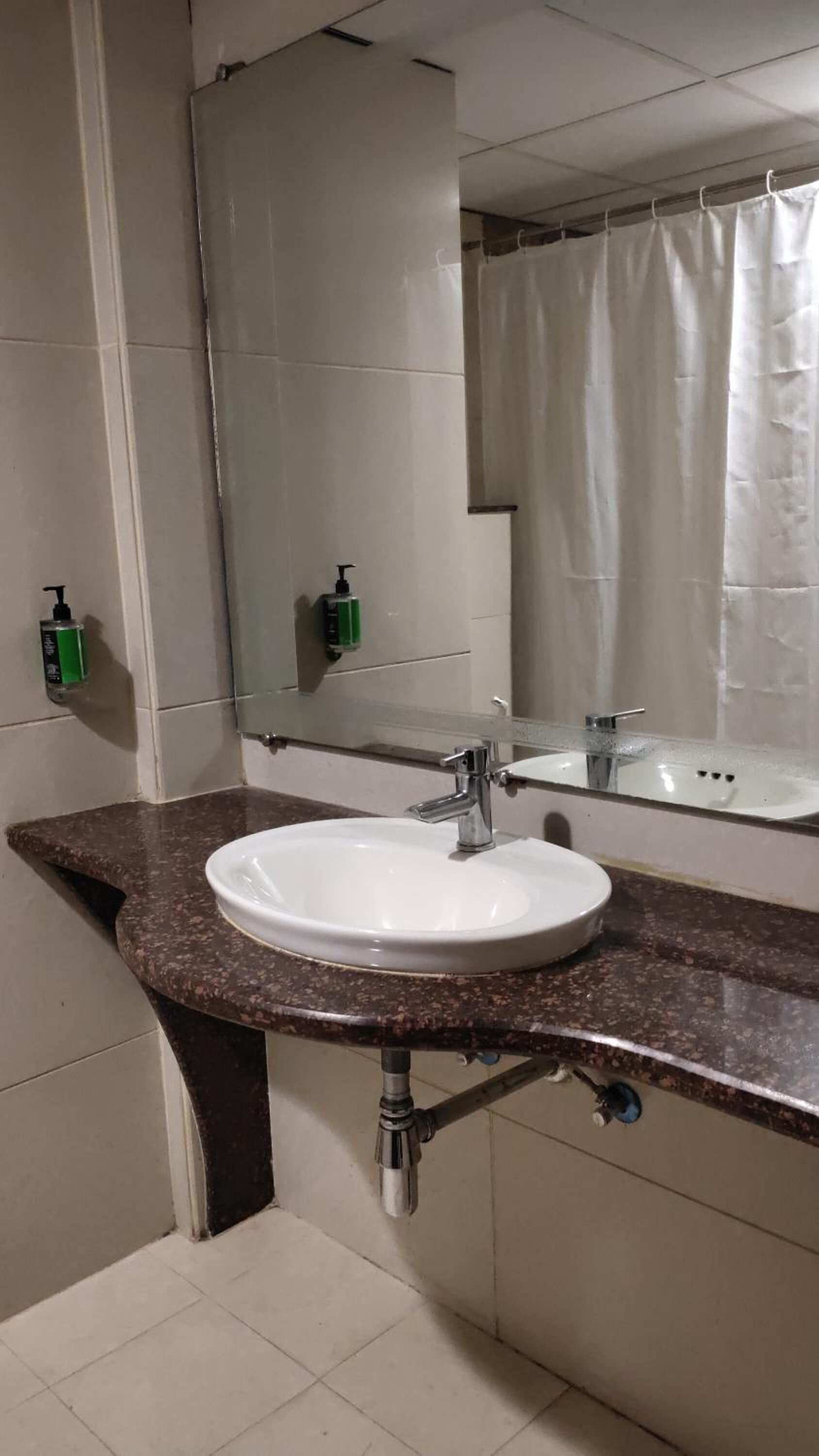 Ein Badezimmer mit Waschbecken, Spiegel und Duschvorhang.