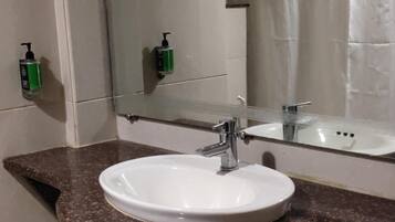 Ein Badezimmer mit Waschbecken, Spiegel und Duschvorhang.