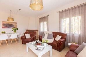 Una sala de estar con chimenea, sofás de cuero, una mesa de centro y un comedor con sillas y una mesa.