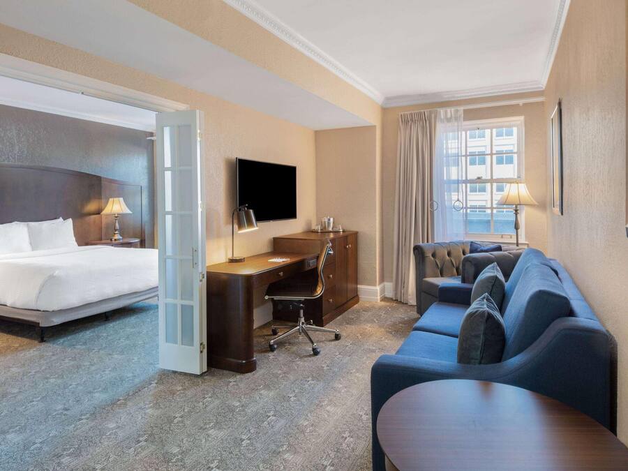 Een hotelkamer met een bed, een bureau, een slaapbank en een televisie.
