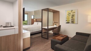 Ein modernes Hotelzimmer mit Bett, Schreibtisch und Sitzecke.