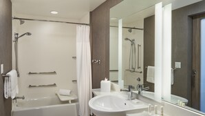 Une salle de bain moderne avec une baignoire, un grand lavabo et un miroir.