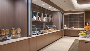 Eine moderne Hotelküche mit einer Selbstbedienungsbereich, einschließlich Essensausgebern und einer Obstauslage.