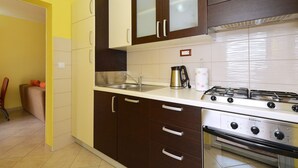 Una cucina con piano cottura a gas, lavello e pensili.
