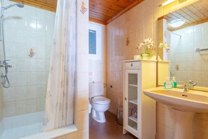 Un baño con ducha, inodoro y lavamanos.