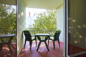 Enjoy a peaceful moment on this balcony with a table and two chairs, offering a serene view of the surrounding landscape.