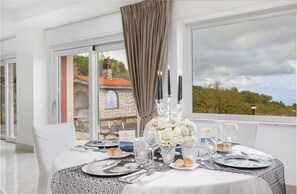 Enjoy a refined dining experience with a beautifully set table for two, complete with a centerpiece and wine glasses.