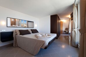 Relax in a spacious room with a large bed, a bedside table, and a large mirror.