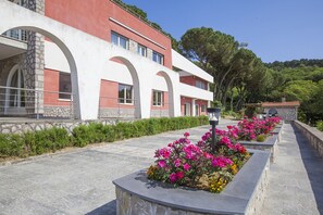 Stunning hotel with arched windows and balconies, set amidst a beautifully landscaped garden.