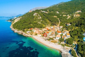 Vista aérea de un pueblo costero con edificios en una colina con vistas a una playa.