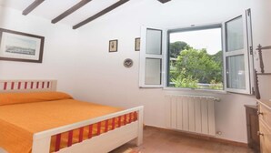 A bedroom with a bed, a window with open shutters, a radiator, and a dresser. - Small Villa on the sea with garden for the perfect holiday (Portoferraio)