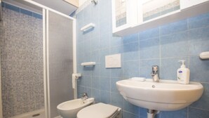 Une salle de bain avec une douche, des toilettes et un lavabo.