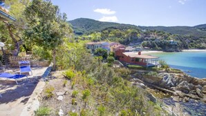 Une propriété située sur la côte, avec vue sur la plage, un sentier en pierre et un espace piscine.