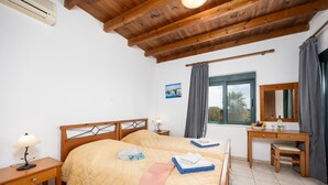 Une chambre à coucher avec un lit en bois, des tables de chevet, un bureau et une fenêtre avec des rideaux.