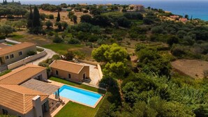 Un barrio residencial con piscina, casas escalonadas y vistas al mar.