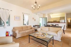 Ein Wohnzimmer mit zwei Sofas, einem Couchtisch und einem Essbereich mit Tisch und Stühlen.