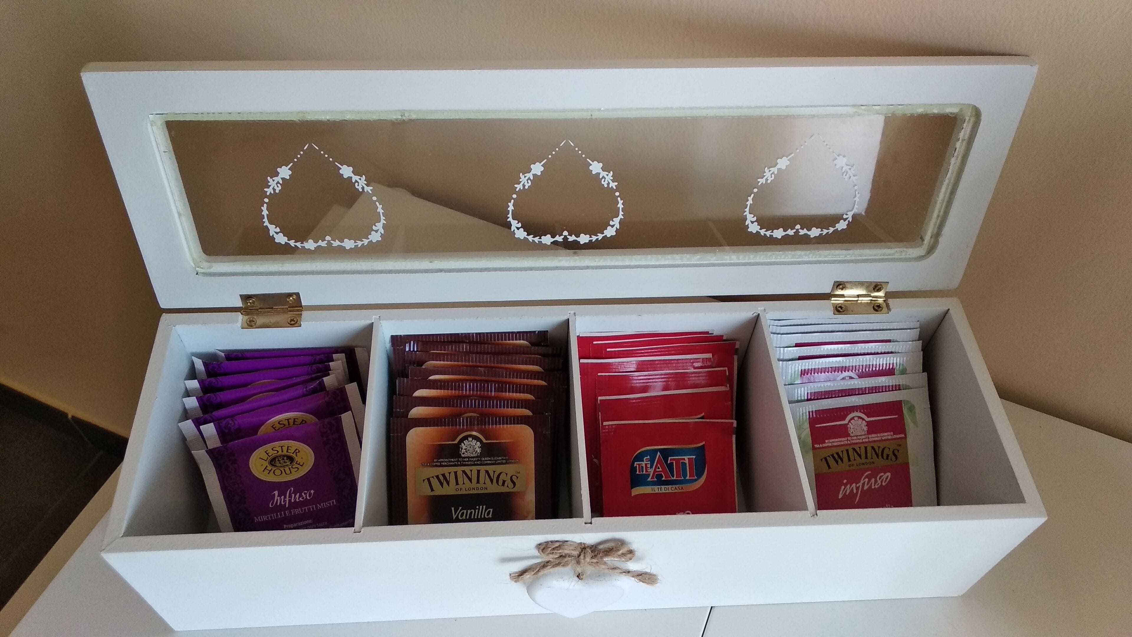 A white box with compartments containing various chocolate bars and a decorative item.